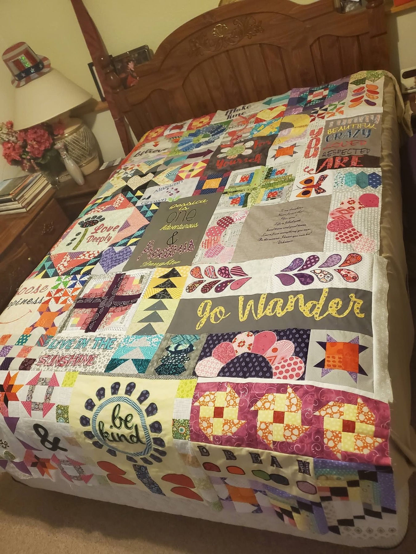 Sampler quilt with 'Go Wander' embroidered lettering